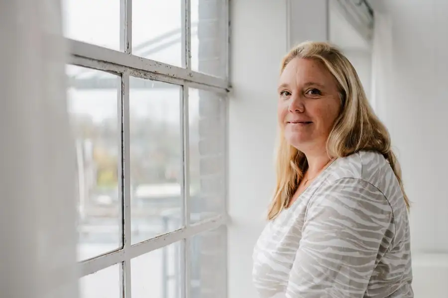 Anne glimlacht bij het raam